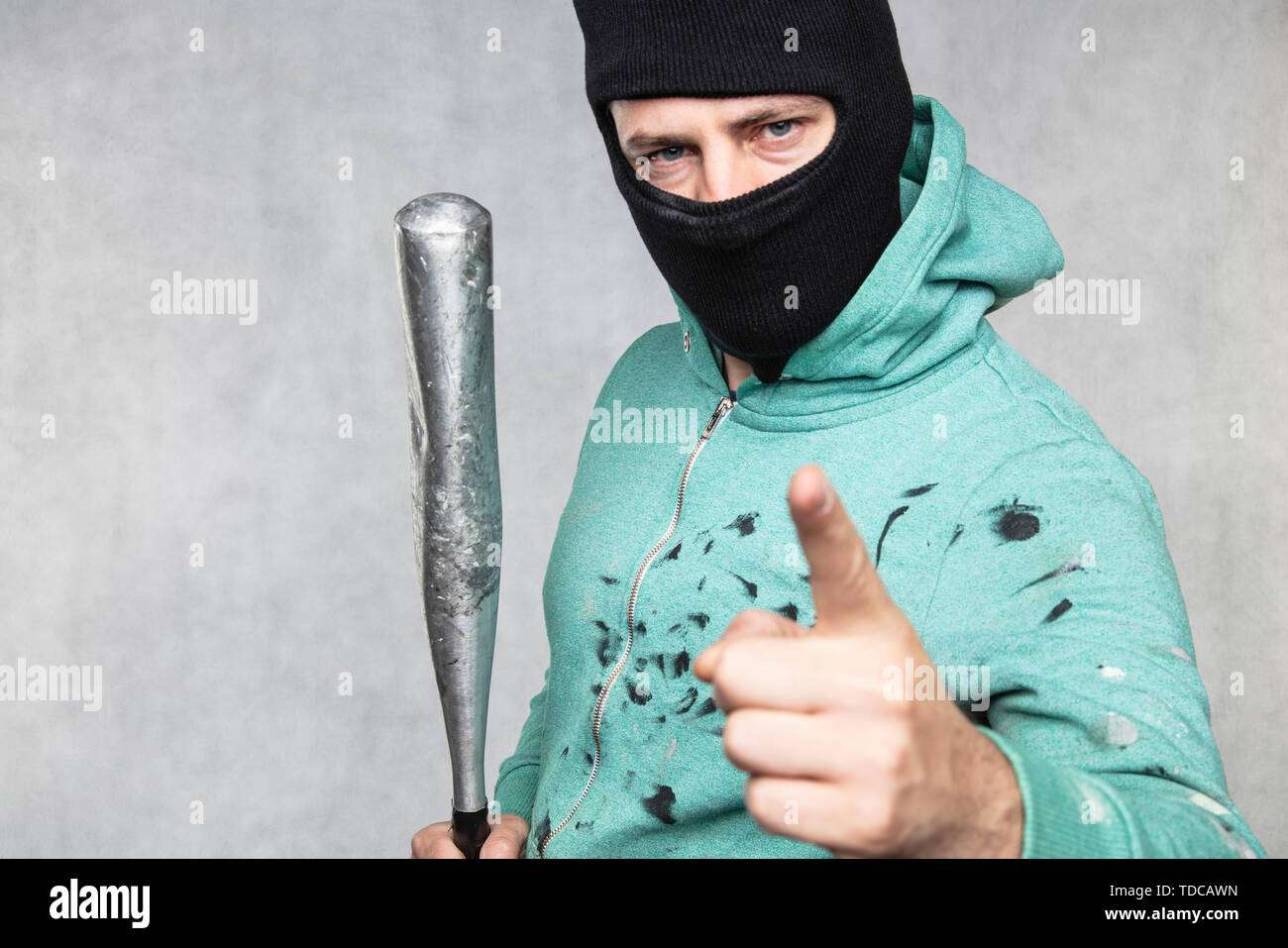 a masked hooligan holds a baseball bat in his hand Stock Photo - Alamy