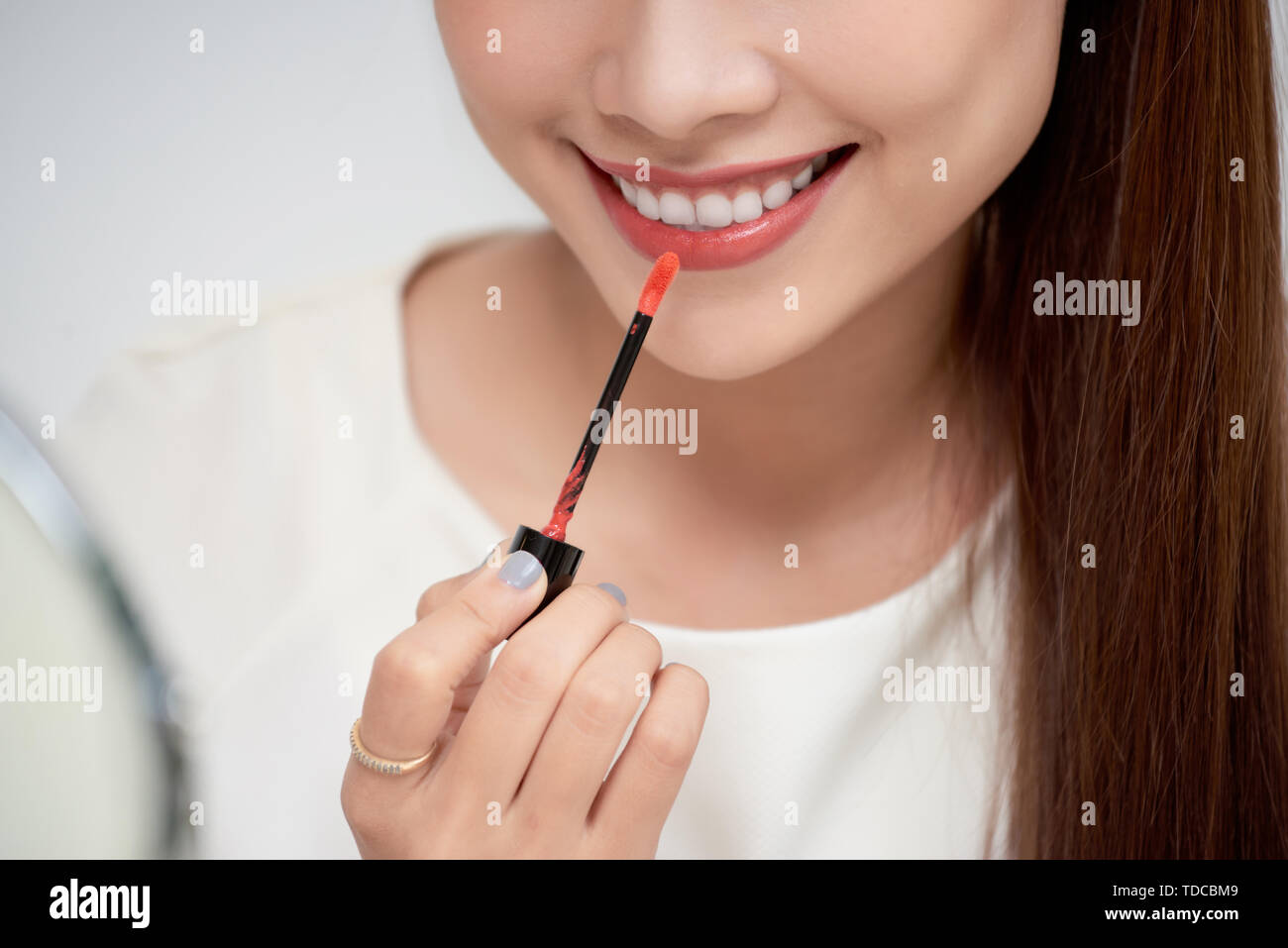 Young beautiful woman professional beauty vlogger or blogger applying lipstick cream to her mouth, doing a make up tutorial Stock Photo