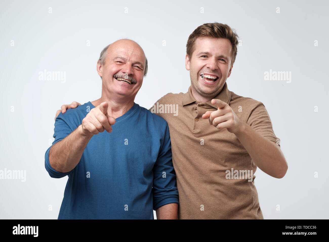Father and son pointing at camera with index finge Stock Photo