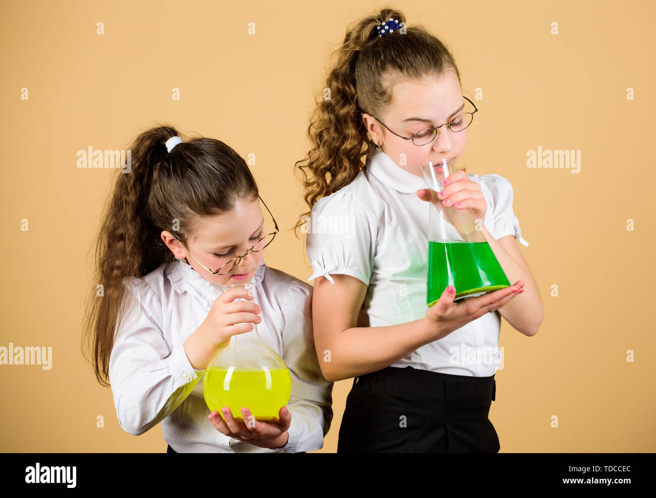 children study at biology lesson. little smart girls with testing flask. knowledge and education. science research in lab. back to school. study chemistry. they love study. small girls study at home. Stock Photo