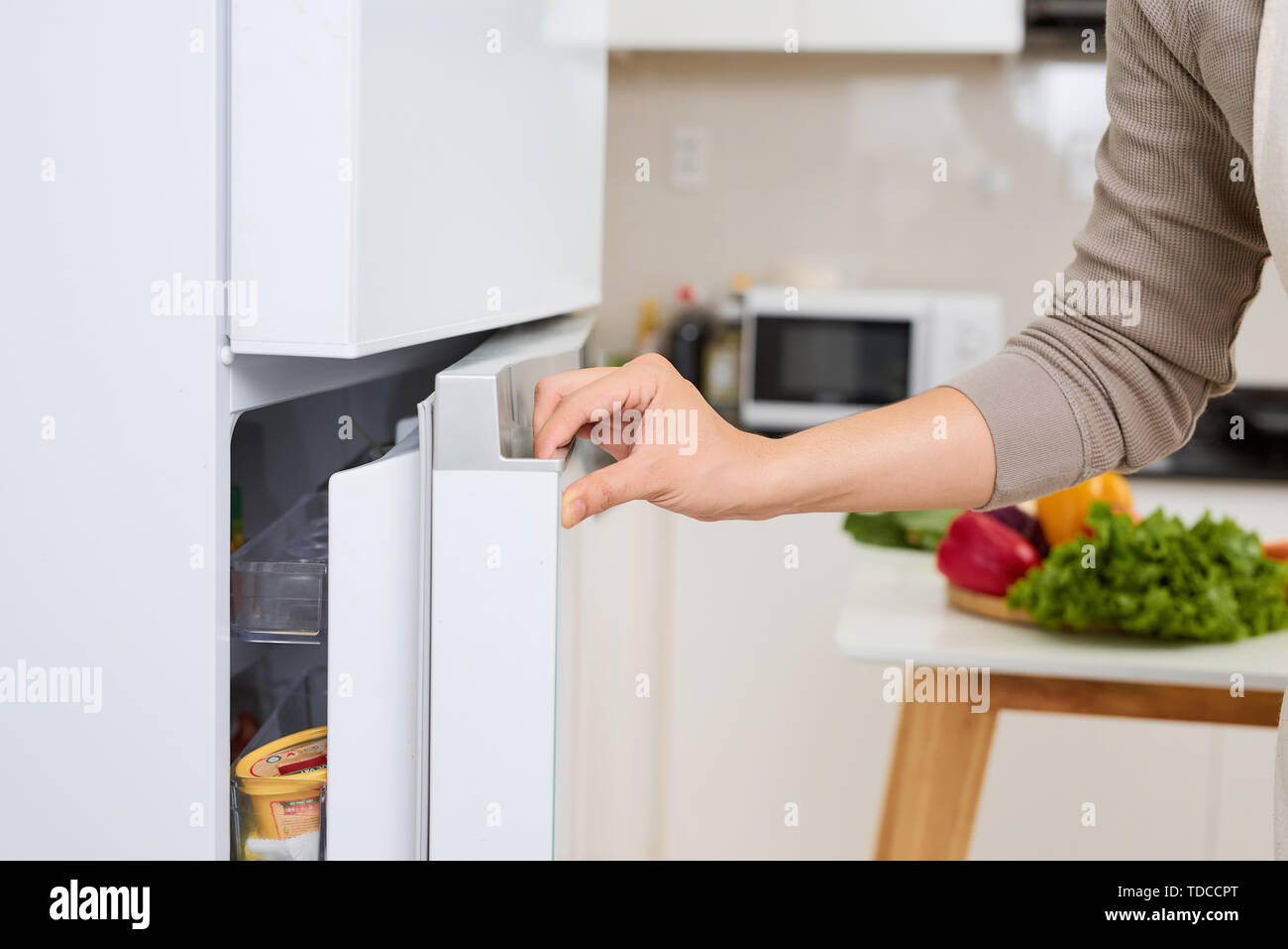 Abstract hand a young man is opening a refrigerator door Stock Photo
