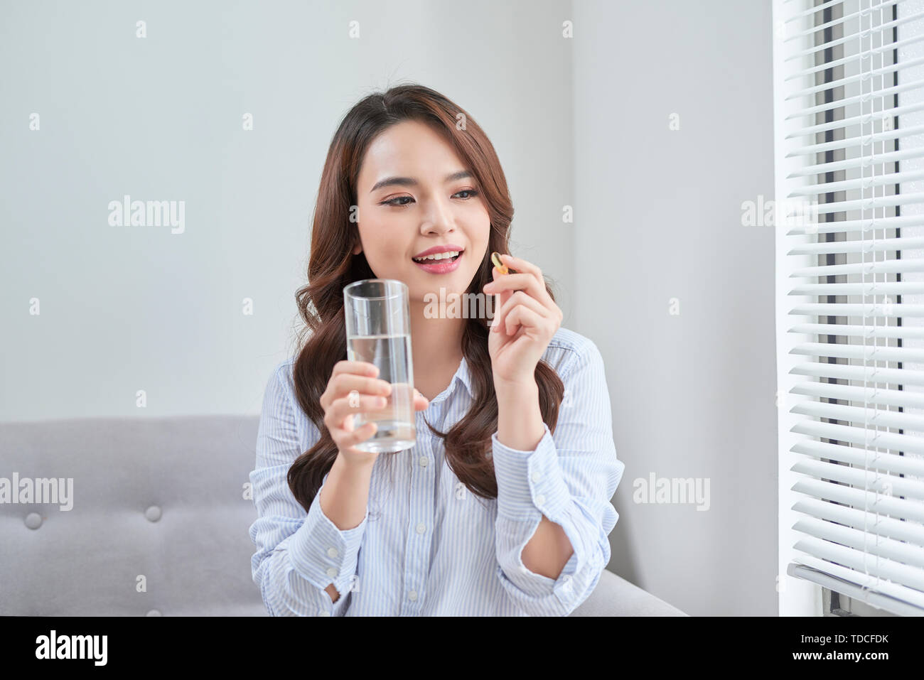 Beautiful Smiling Woman Taking Vitamin Pill. Dietary Supplement Stock Photo