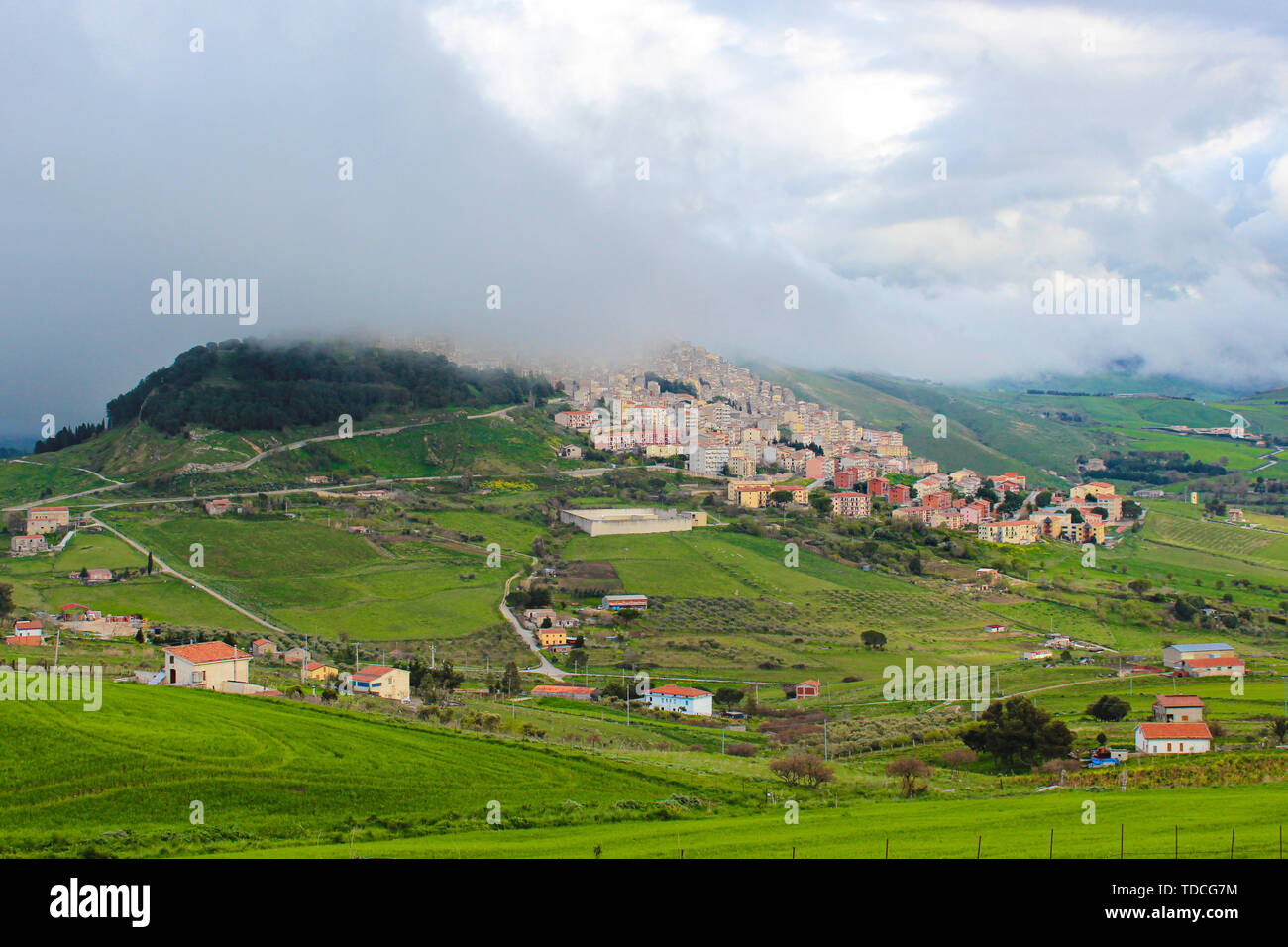 Amazing view of village Gangi in Sicily, Italy photographed in foggy weather. The historical city is located on the top of the hill. Green countryside landscape. Fog. Sicilian countryside. Stock Photo