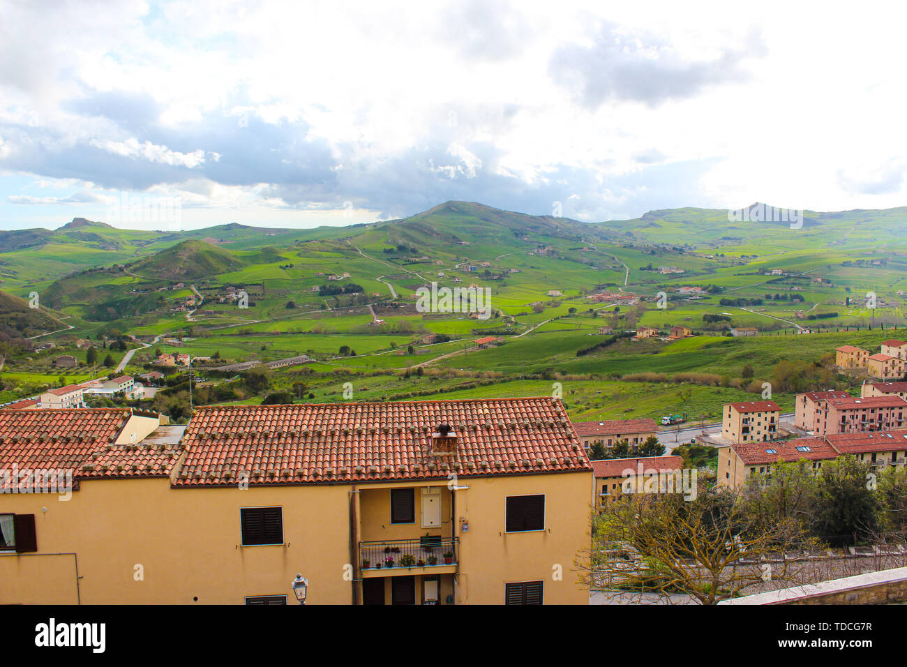 Beautiful view of green Sicilian countryside landscape photographed from small village Gangi. Nature and cities in Italy. Houses in the city. Hilly landscape, mountains. Cloudy weather. Stock Photo