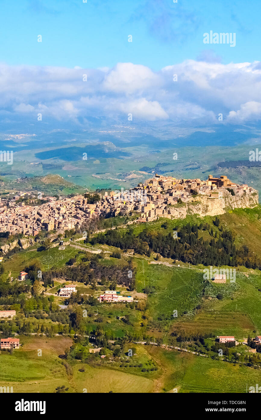 Historical Arab village Calascibetta on the top of the hills in Sicily, Italy. Taken with nearby mountains and green landscape. Photographed from Enna. Norman era fortress. Stock Photo