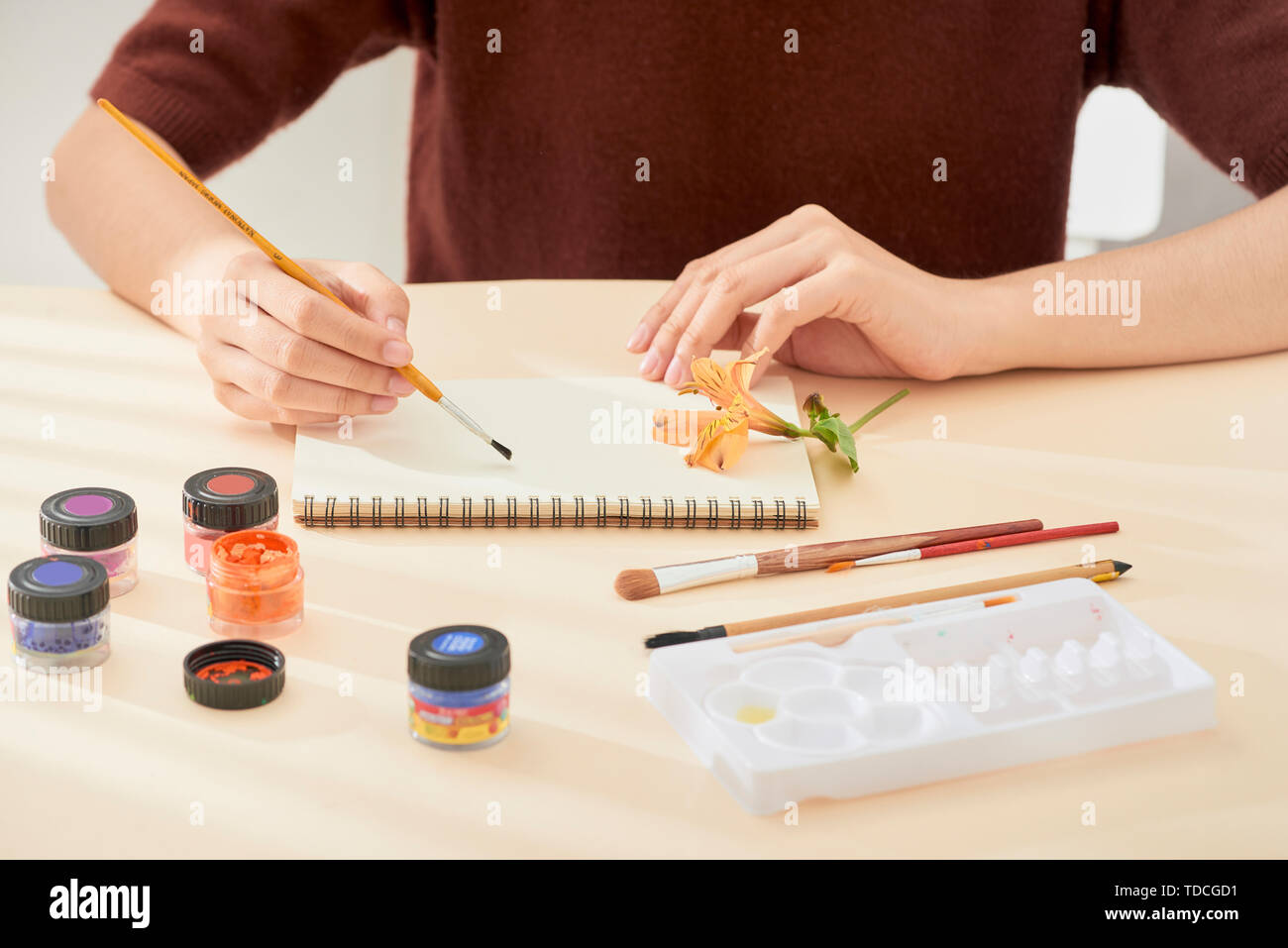 women's hand with brush drawing on notepad. Creation process of