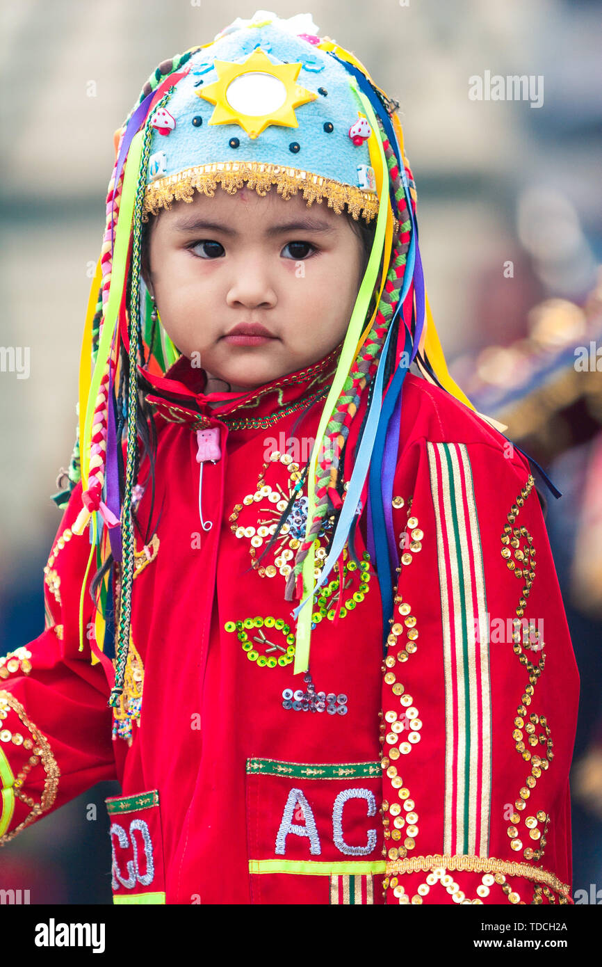 Lima / Peru - June 15.2008: Portrait of the latin baby girl dressed up in traditional, folklore peruvian colorful costume during the street parade. Stock Photo