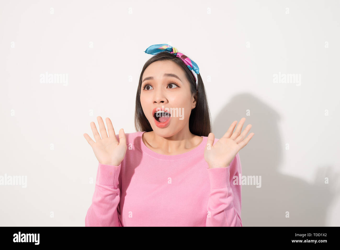 Asian Young Woman in Surprising Emotion, Face Look up above with opened mouth and hands, Emotional of Female Concept, Front view Stock Photo