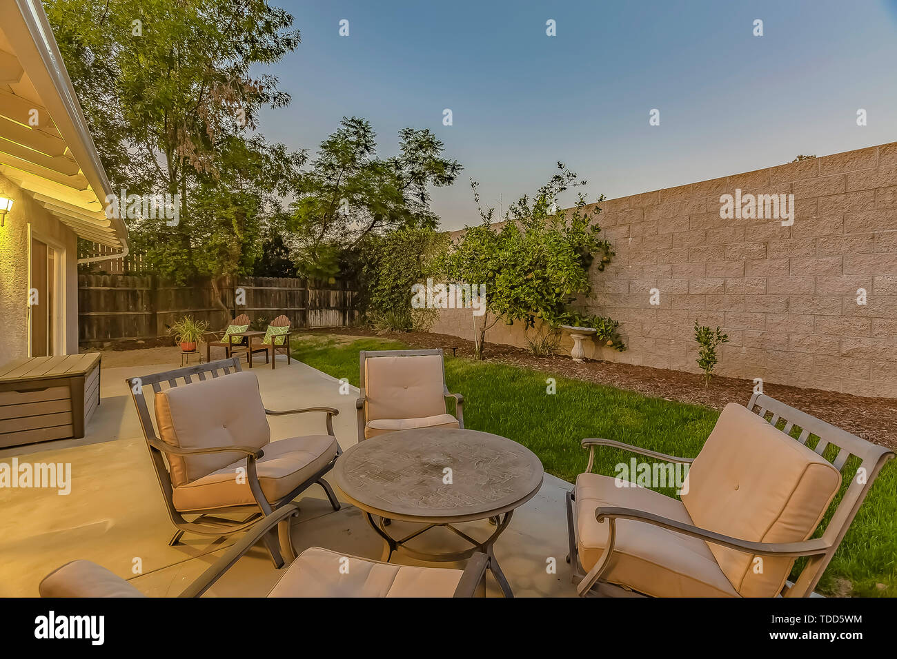 Round Table And Cushioned Armchairs On The Patio Of A House