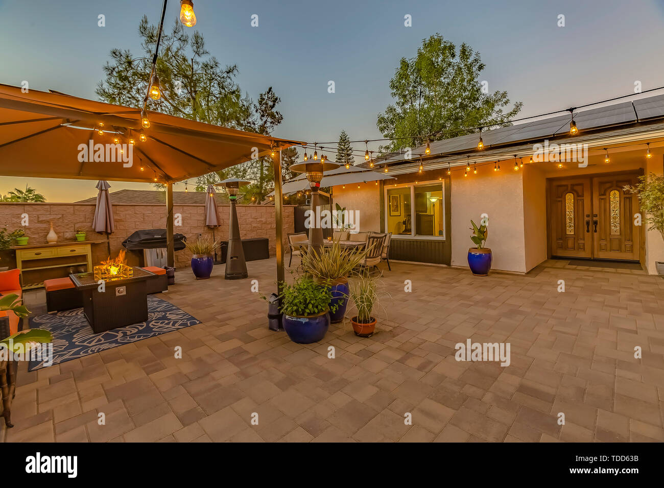 Cozy Stone Patio With String Of Lights Over A Covered