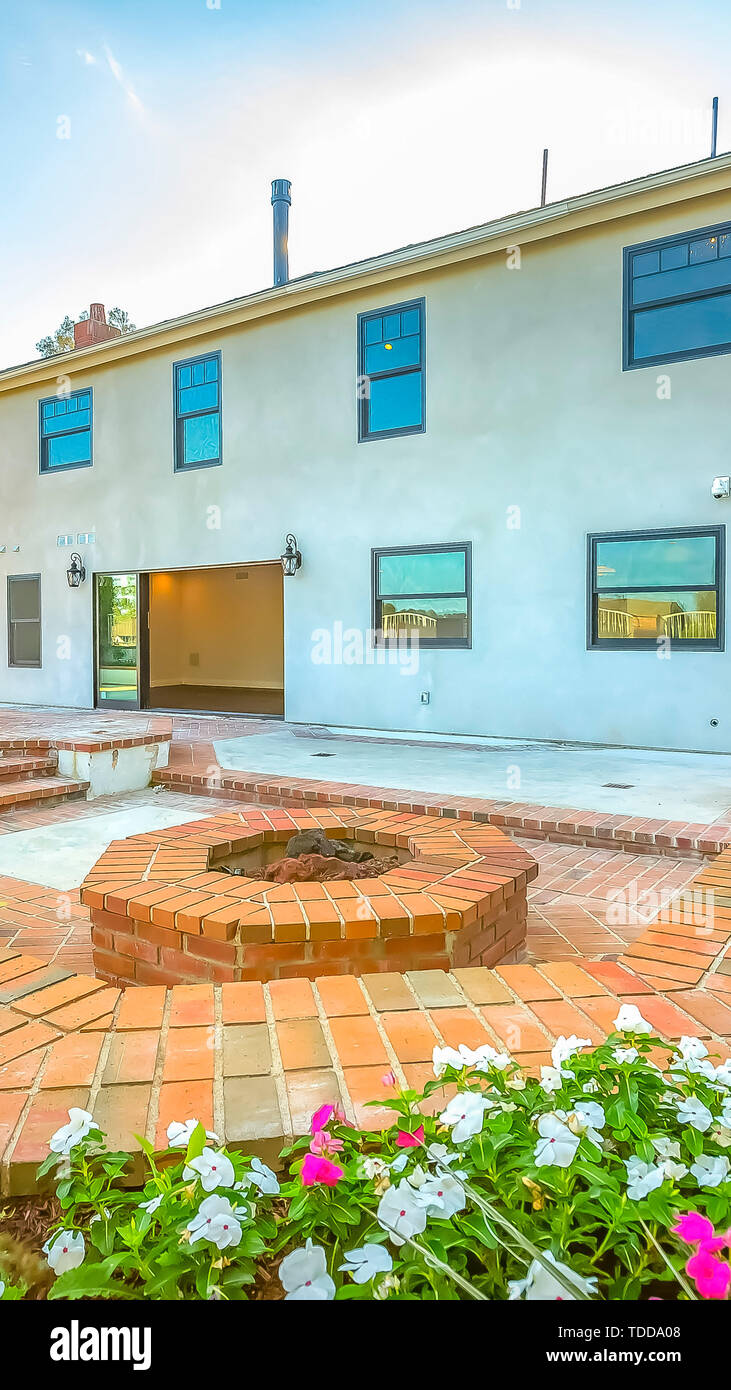 Vertical frame House with a stone brick patio and octagonal fire pit ...
