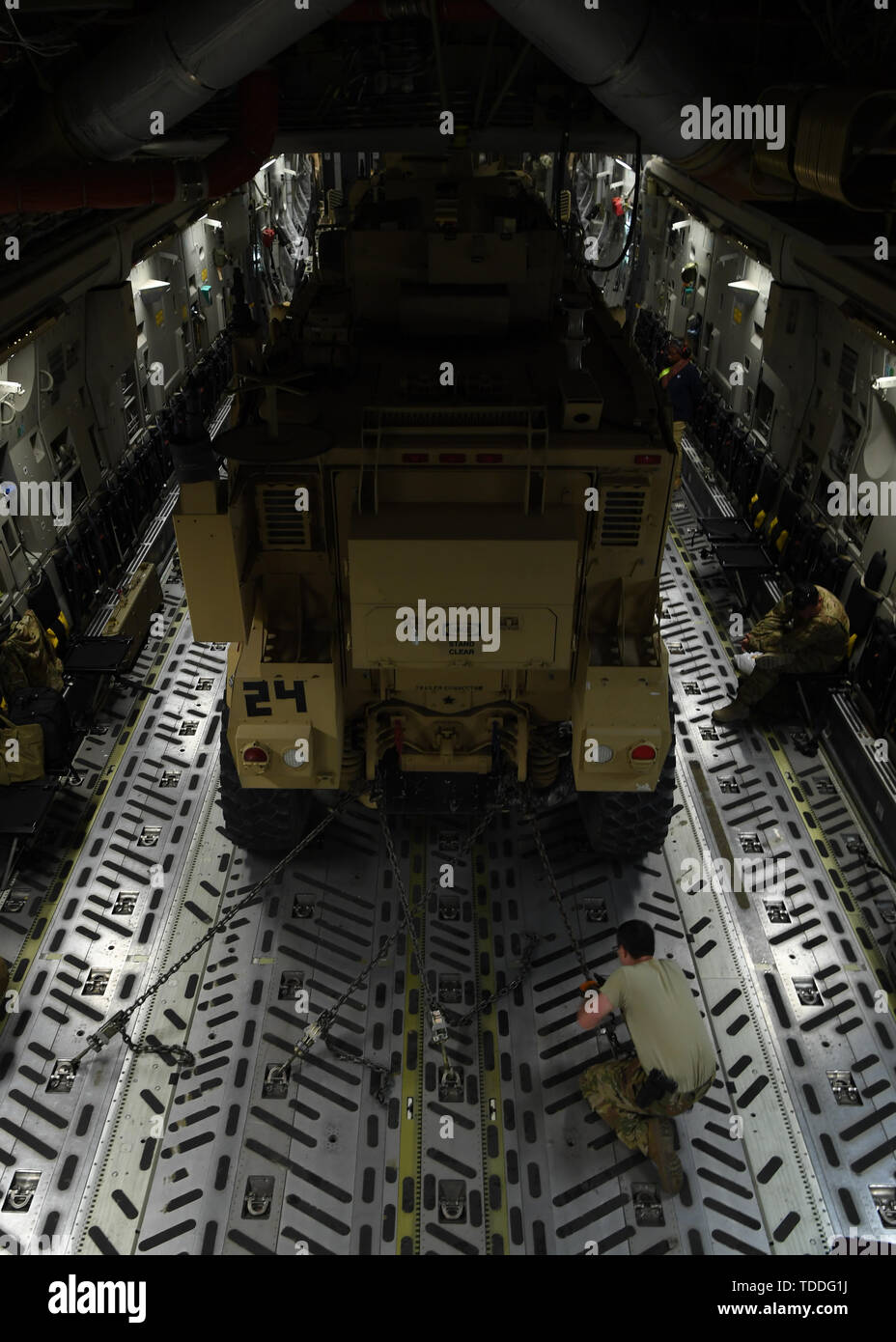 A U.S. Air Force loadmaster from the 816th Expeditionary Airlift Squadron out of Al Udeid Air Base, Qatar, secures a MaxxPro mine-resistant, ambush protected vehicle to a C-17 Globemaster III during a transport mission, June 5, 2019. The 816th EAS provides a constant presence in the region, delivering equipment, supplies and personnel allowing U.S. Air Forces Central Command to leverage and outmatch those seeking to challenge U.S. and coalition interests. (U.S. Air Force photo by Staff Sgt. Chris Drzazgowski) Stock Photo