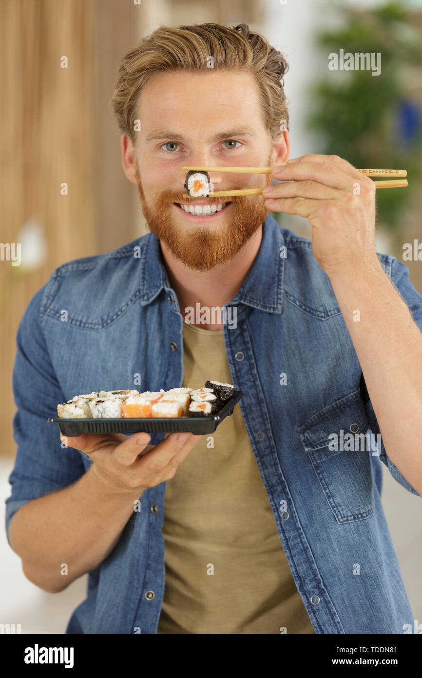 happy young man eating sushi Stock Photo