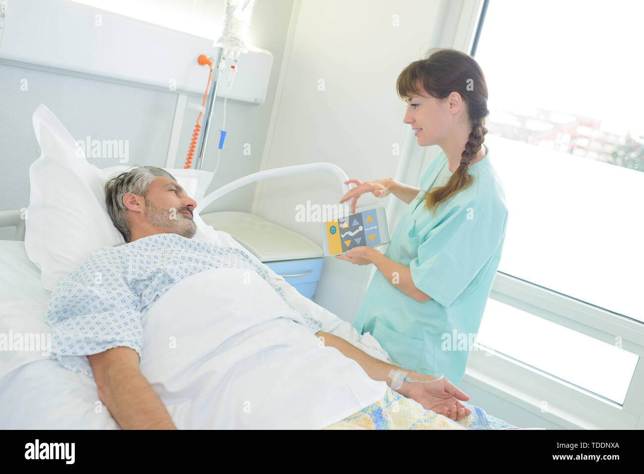 nurse explaining bed controls to hospital patient Stock Photo Alamy