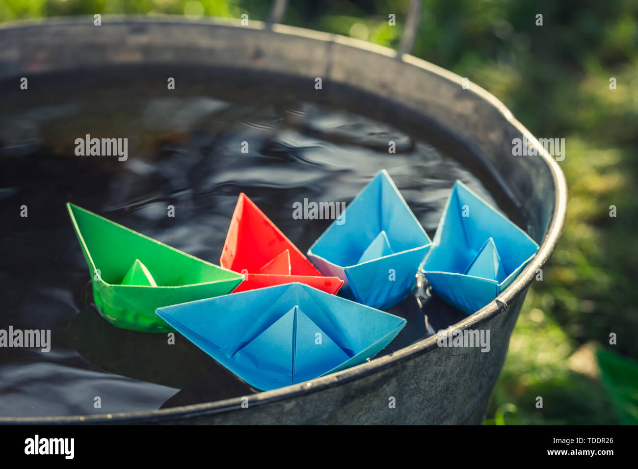 Blue paper boats floating on water in washtube Stock Photo