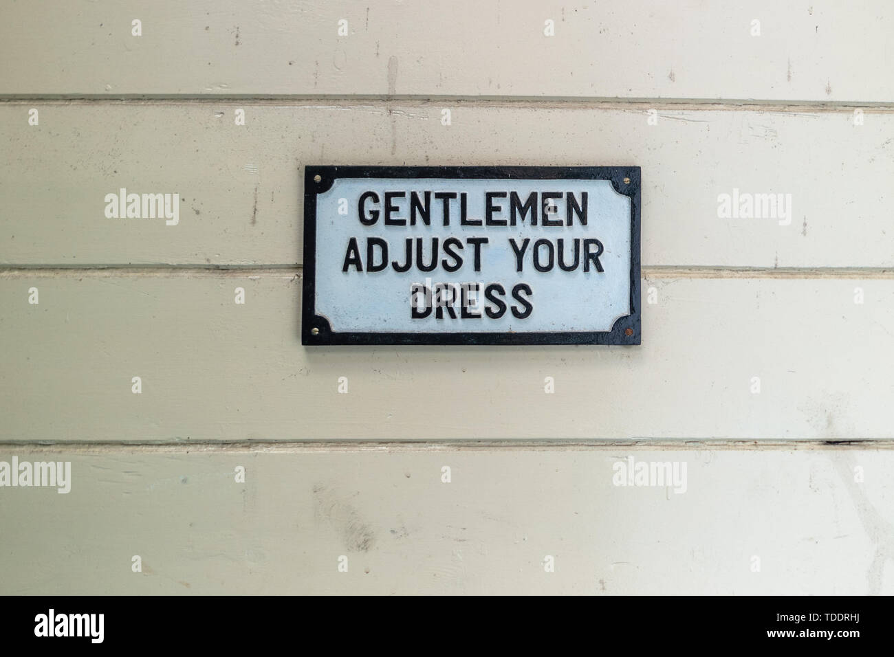 Genteman adjust your dress sign, taken outside Gents loo at Eridge station Stock Photo