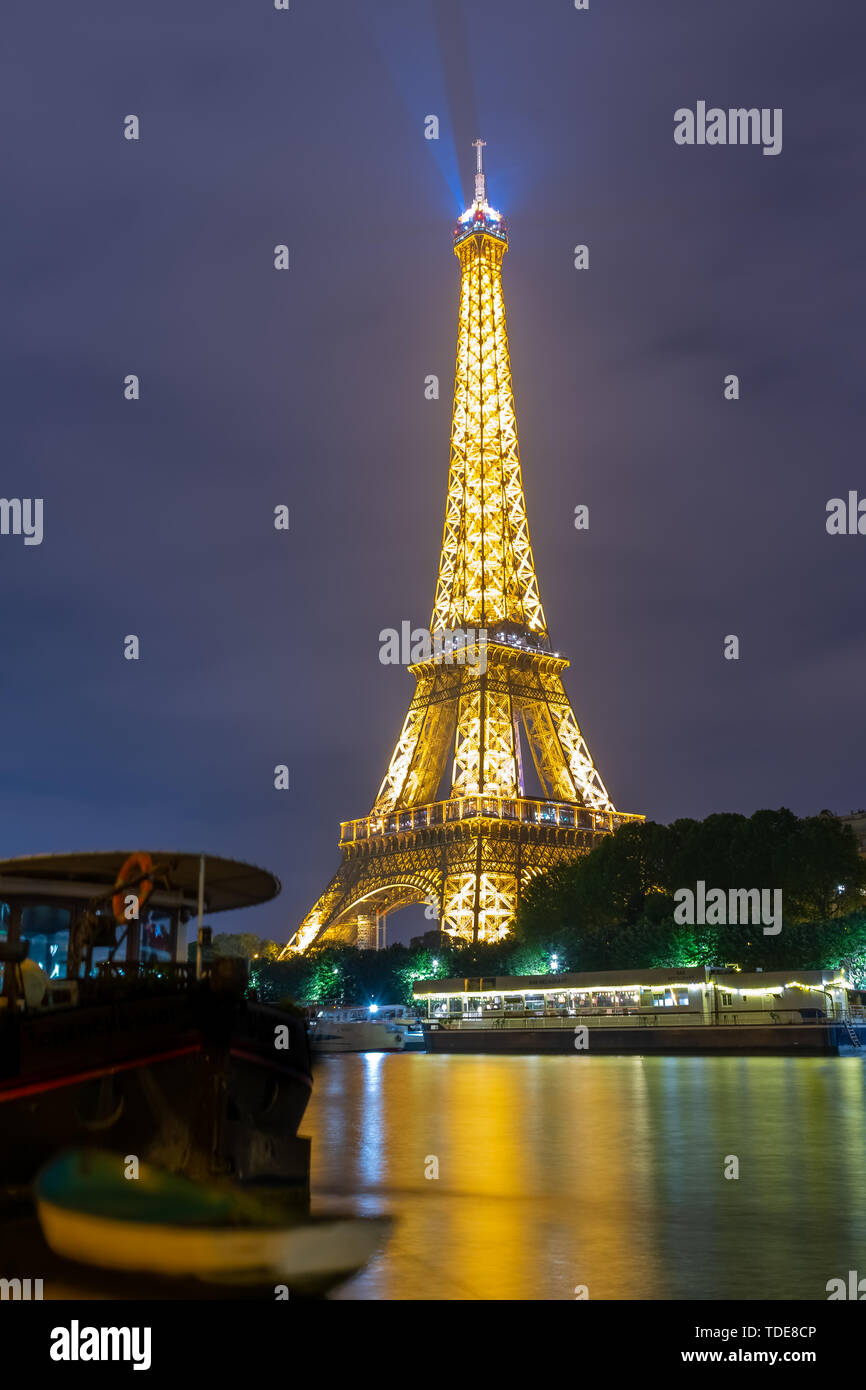 Famous Eiffel tower and Seine river with colorful reflections at night ...