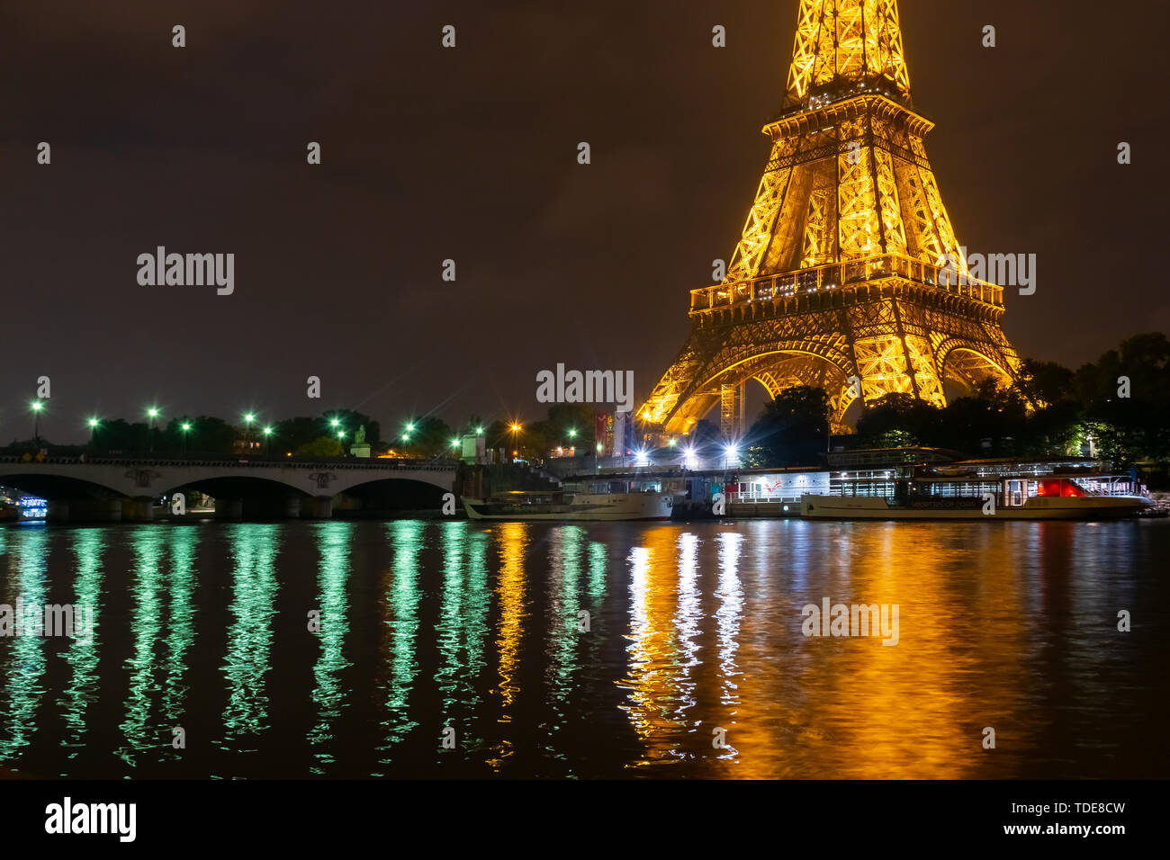 Famous Eiffel tower and Seine river with colorful reflections at night ...