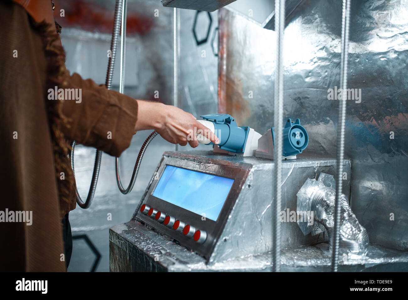 Space scientist holds wires at the control panel Stock Photo