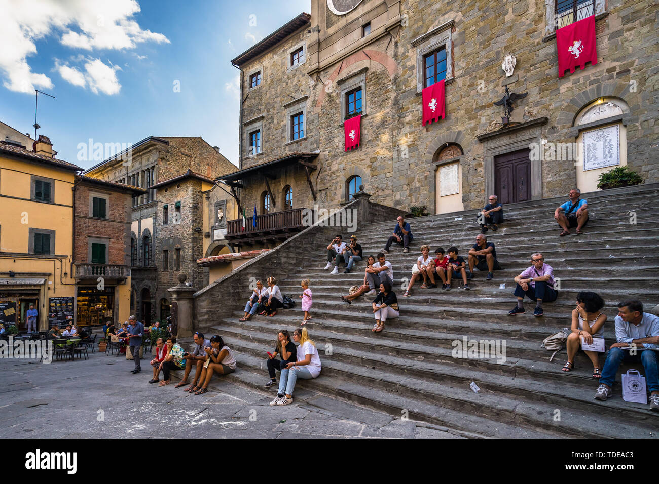 People enjoying the lively atmosphere of Cortona sitting on the