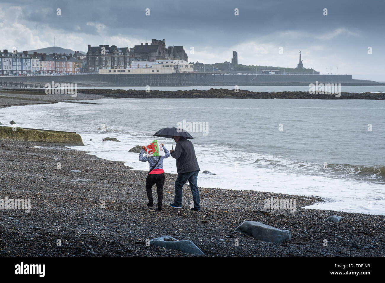 Aberystwyth Wales UK, Saturday 15th June 2019  UK Weather: A couple have the beach to themselves on a grey and wet afternoon at the seaside in Aberystwyth , west wales, as the dreary wet and very unsesonal June ‘summer’ weather continues its hold on the country  photo credit Keith Morris / Alamy Live News Stock Photo