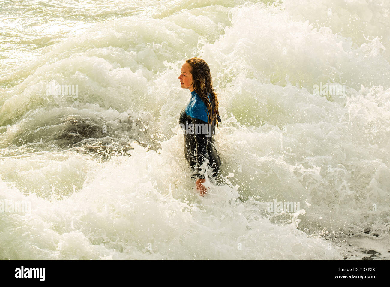 Aberystwyth, UK. 15th June, 2019. UK Weather: A young woman bodysurfing in the waves by the sea wall in Aberystwyth , west wales, on a fine bright evening after a day of mixed sunshine and showers,  as the dreary wet and very unseasonal June ‘summer’ weather continues its hold on the country   Credit: keith morris/Alamy Live News Stock Photo
