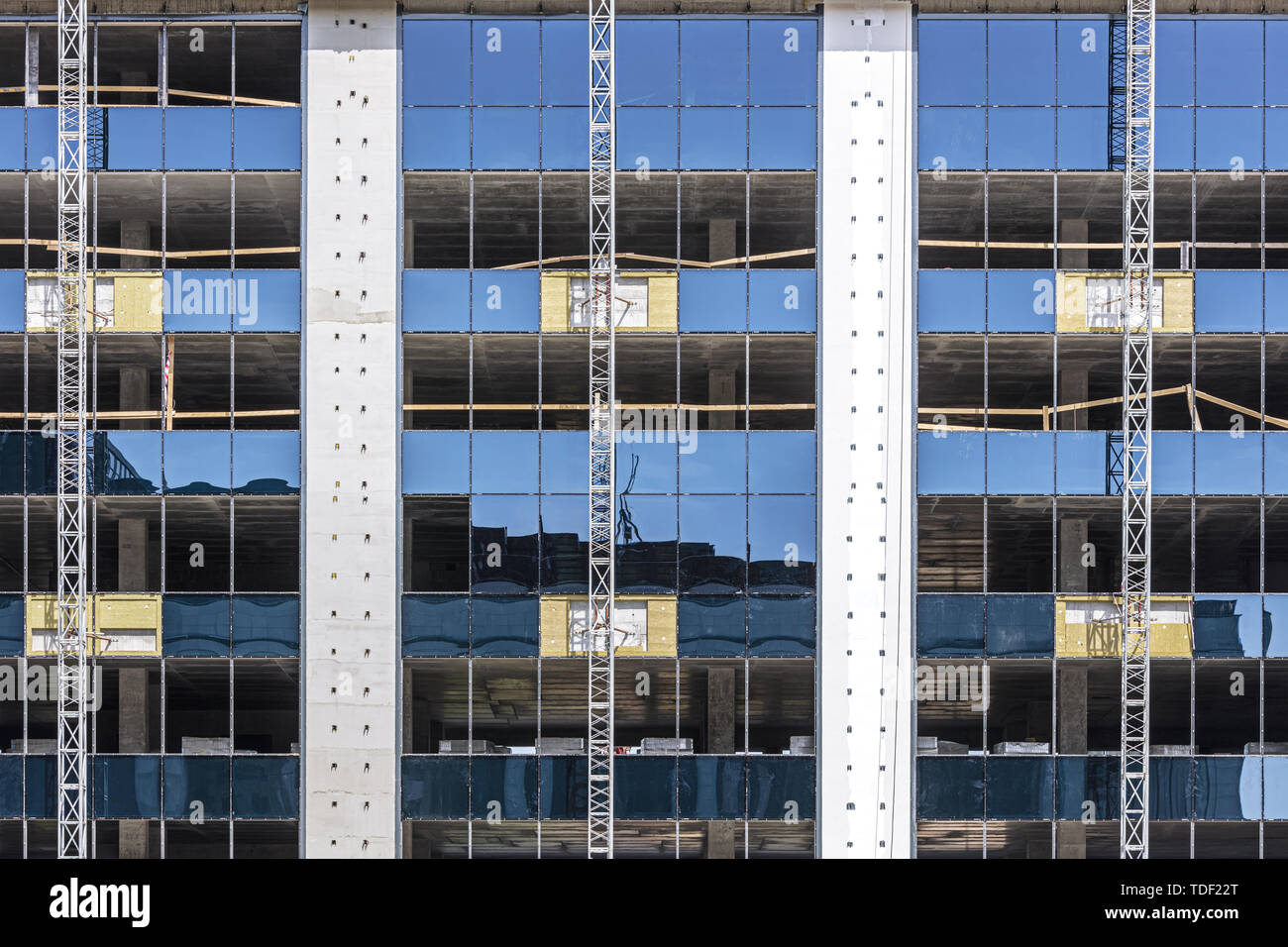 modern office building under construction. blue sky reflection in glass facade. industrial background Stock Photo