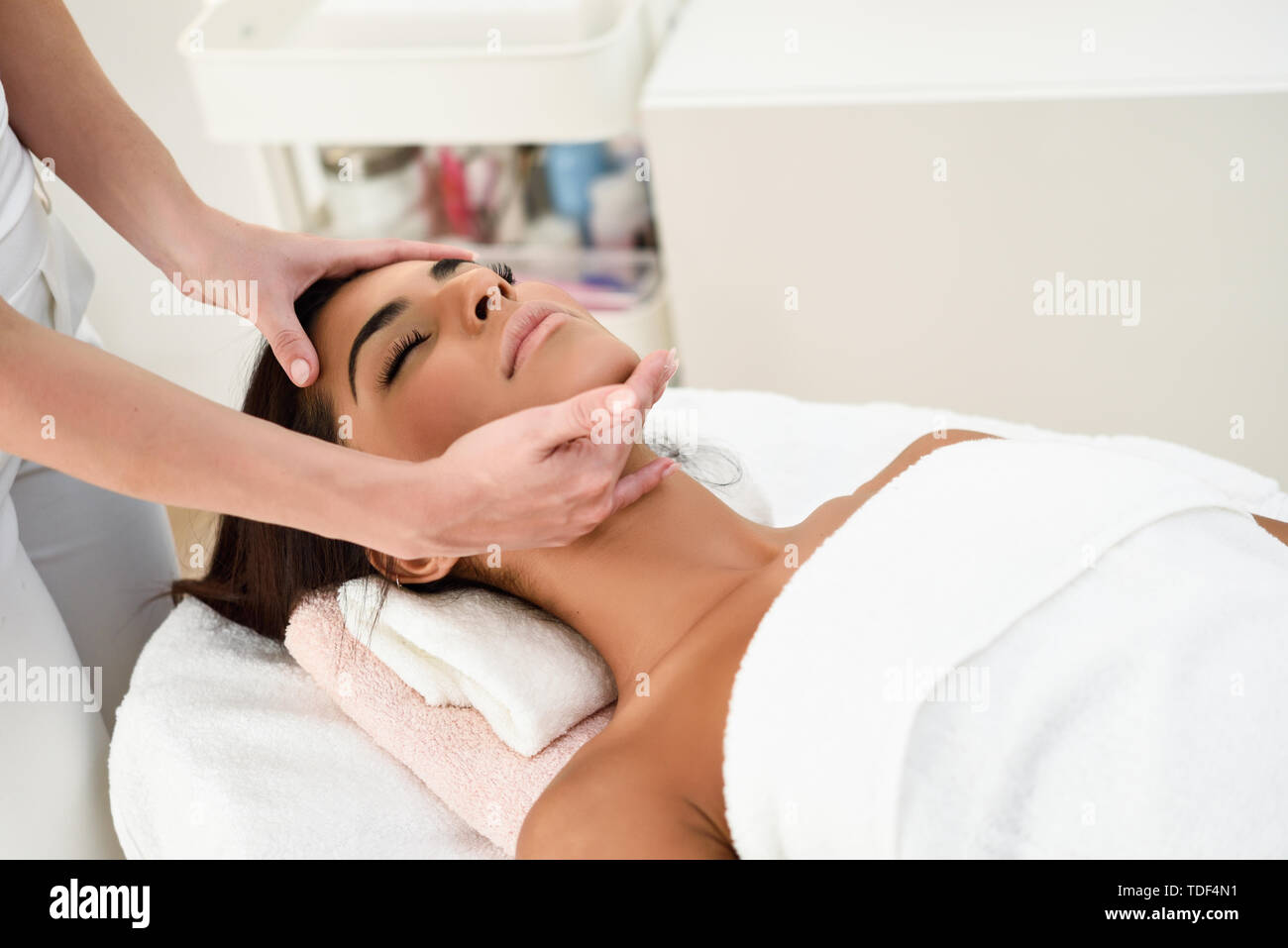 Woman receiving head massage in spa wellness center. Stock Photo