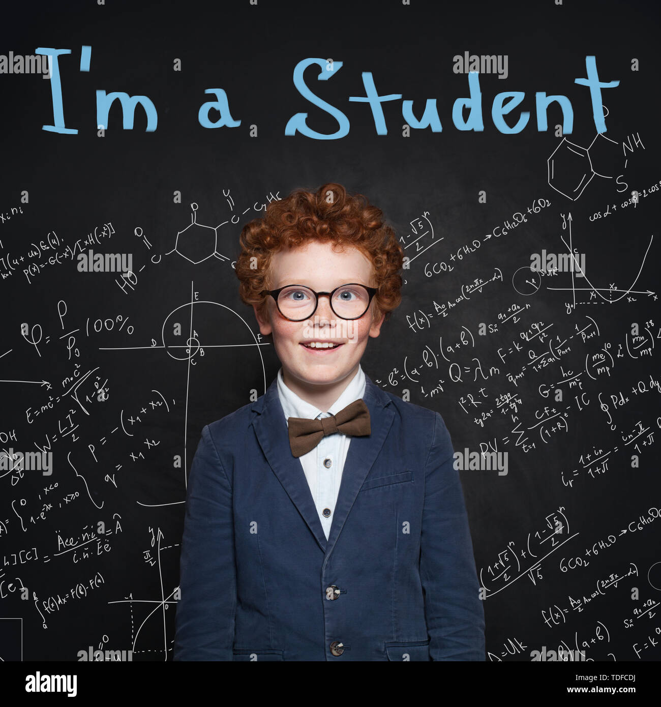 Clever child pupil on blackboard background portrait. Back to school