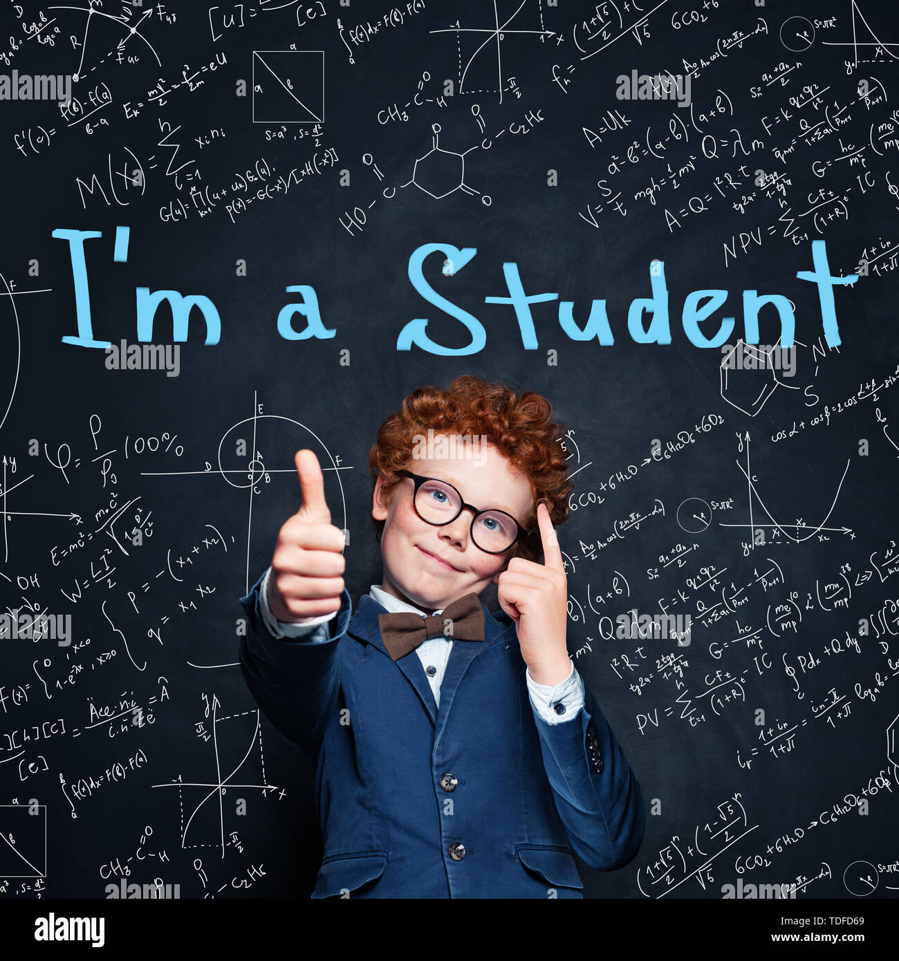 Smart child schoolboy showing thumb up on blackboard background. Back ...