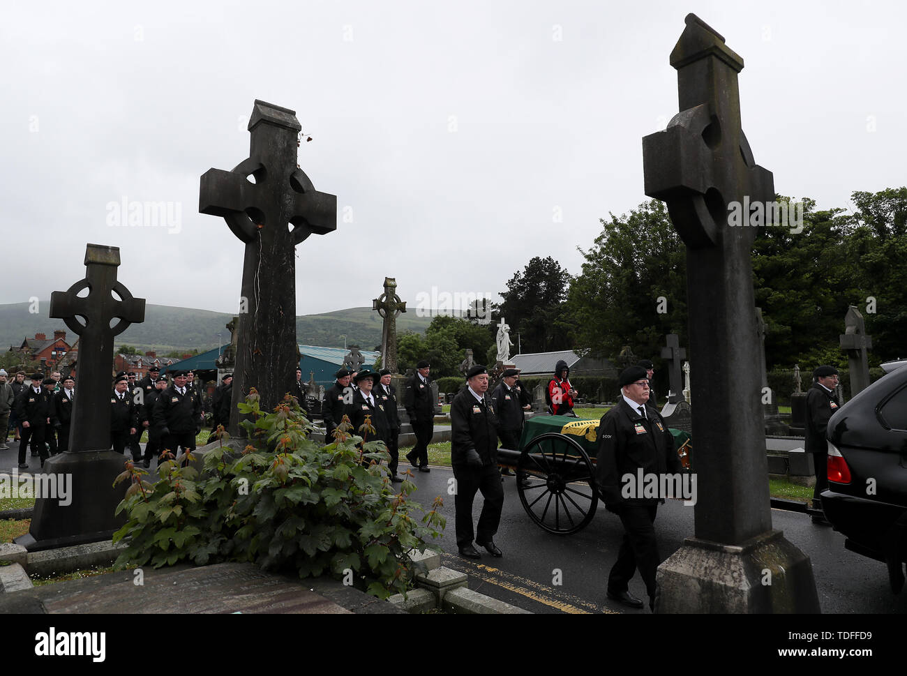 The coffin of former Provisional IRA leader Billy McKee is accompanied by members of 'D Company' as it enters Milltown cemetery in Belfast. Stock Photo