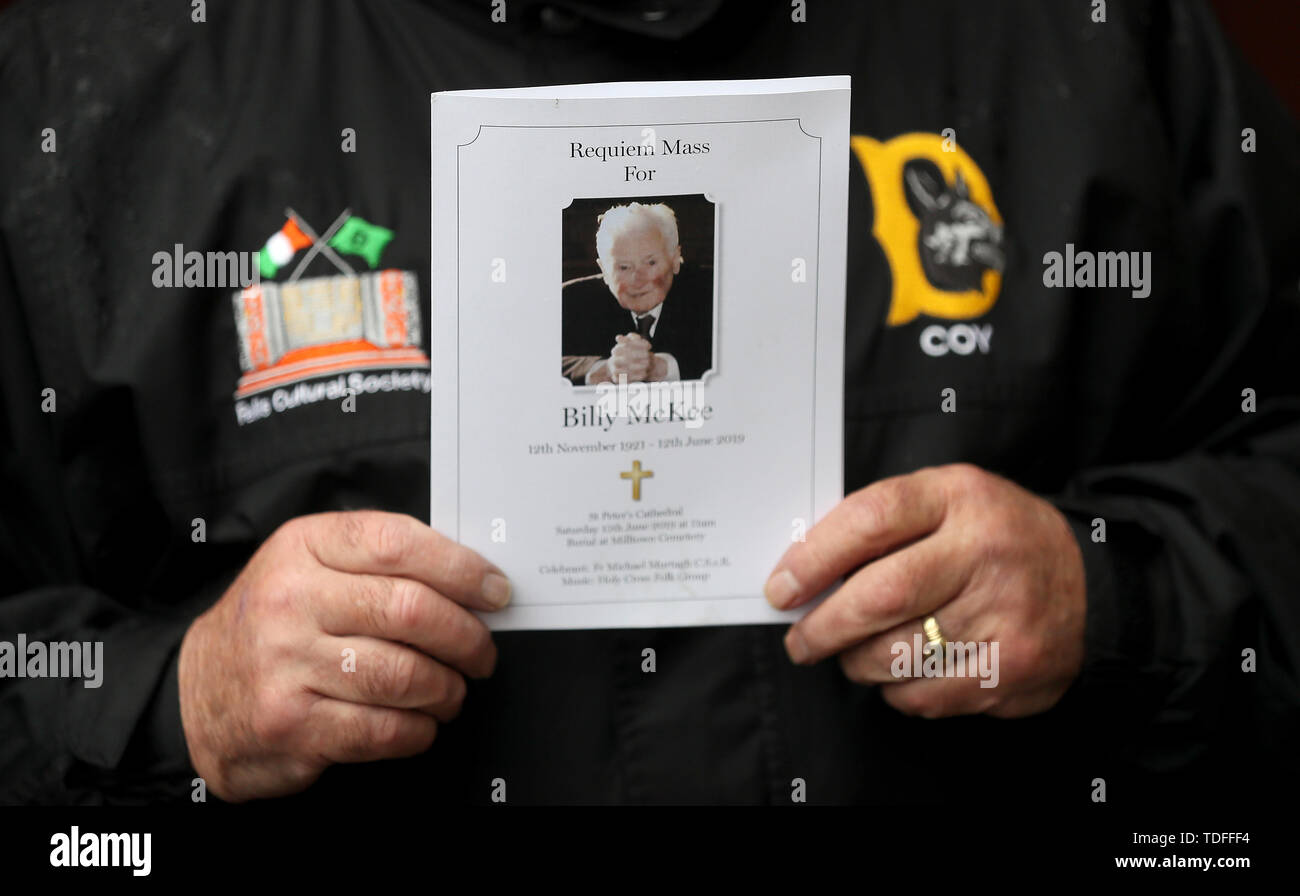 A Member Of D Company Holds A Mass Card At The Funeral Of Former