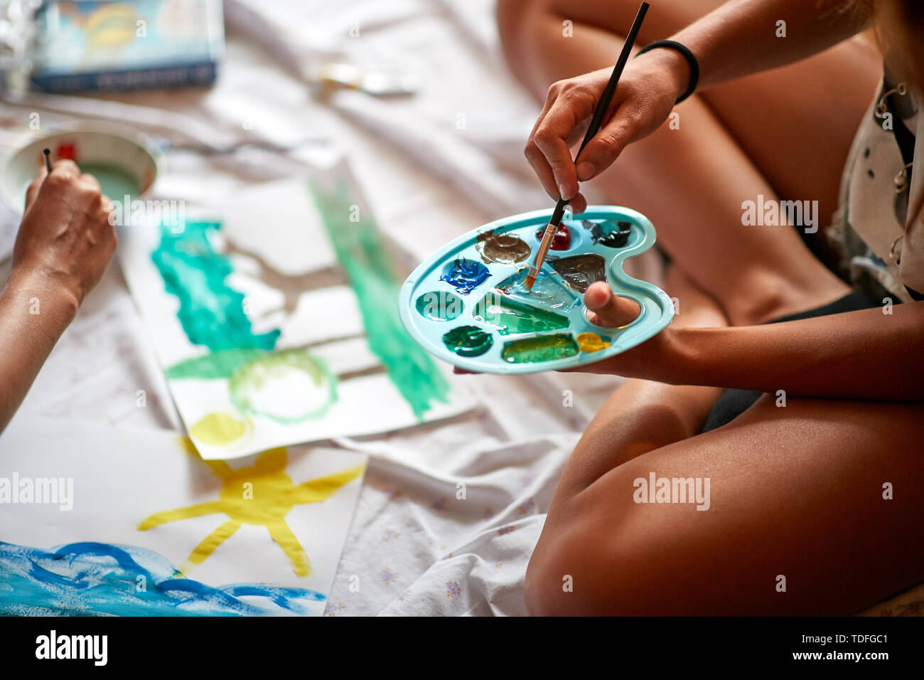 Girl holding palette with paints and brush, concept Stock Photo