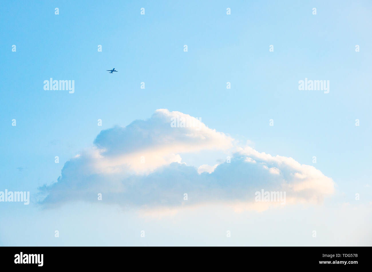 The plane on the blue sky and white clouds. Stock Photo