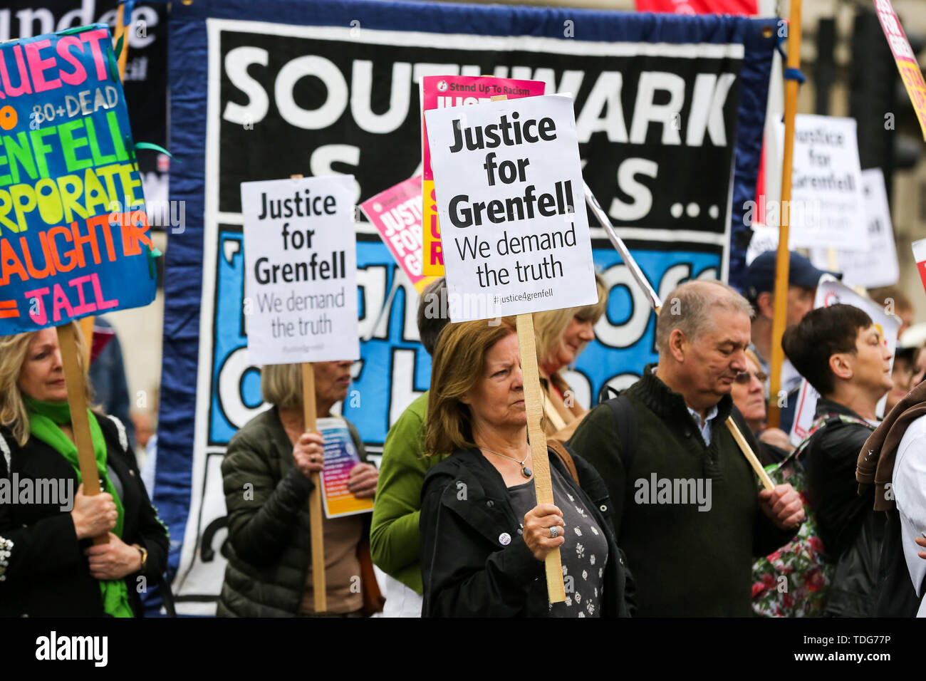 Campaigners hold placards during the Justice for Grenfell Solidarity rally against the lack of action by the Government following the Grenfell Tower fire, in rehousing affected families, delays in the Public Inquiry, tower blocks still covered in flammable cladding, soil contamination and the performance of Royal Borough of Kensington and Chelsea. On 14 June 2017, just before 1:00 am a fire broke out in the kitchen of the fourth floor flat at the 24-storey residential tower block in North Kensington, West London, which took the lives of 72 people. More than 70 others were injured and 223 peopl Stock Photo