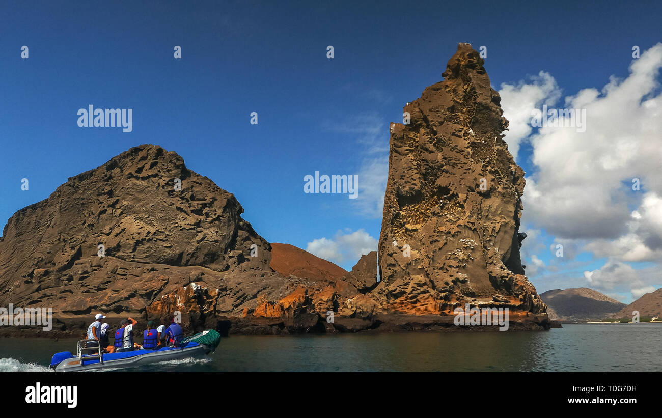the view of pinnacle rock and a zodiac dinghy with tourists at isla bartolome in the galapagos Stock Photo