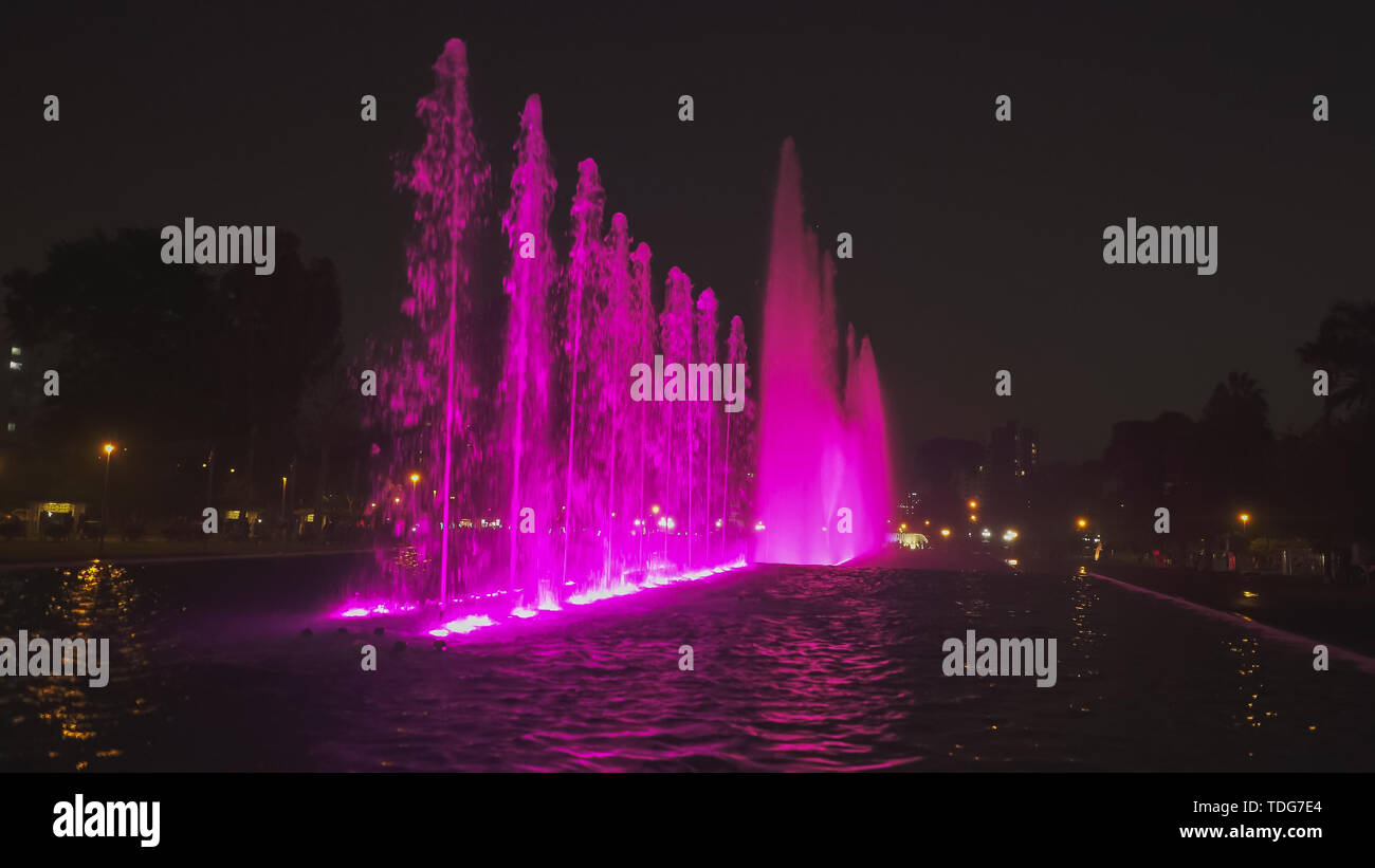 night shot of a purple lit  fountain on the magic water circuit in lima, peru Stock Photo