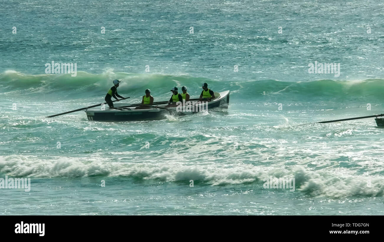 ALEXANDRA HEADLAND, QUEENSLAND, AUSTRALIA- APRIL 21, 2016: backlit shot of surf boats battling waves in a race on the sunshine coast of australia Stock Photo
