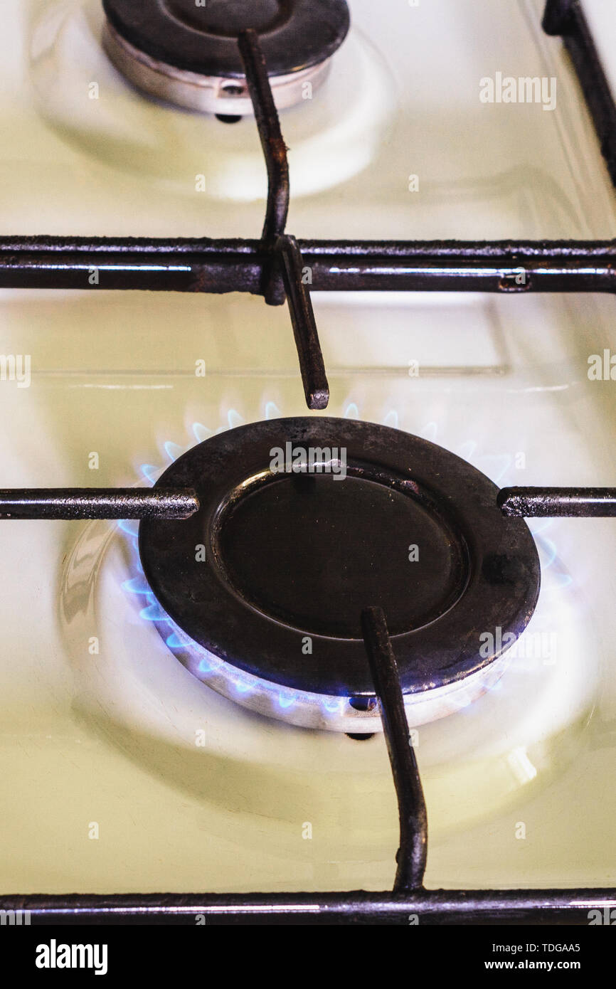 On the white gas stove the burner is lit from which the flame of