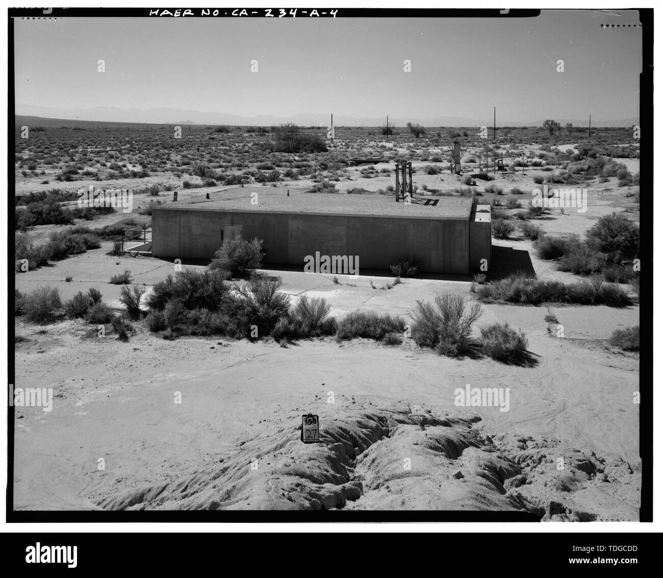 NORTH SIDE, AND ROOF, EASTERNMOST CAMERA STAND SHOWN IN RIGHT MIDDLE DISTANCE. Looking west from top of protective berm near Air Supply building. - Edwards Air Force Base, South Base Sled Track, Firing Control Blockhouse, South of Sled Track at east end, Lancaster, Los Angeles County, CA Stock Photo