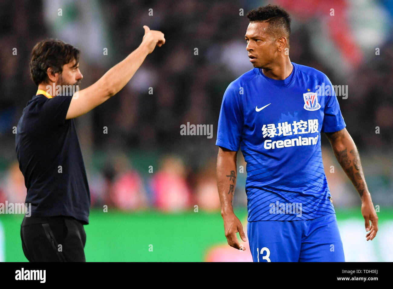 Colombian football player Giovanni Moreno of Shanghai Greenland Shenhua celebrates with head coach Quique Sanchez Flores after scoring against Beijing Sinobo Guoan in their 13th round match during the 2019 Chinese Football Association Super League (CSL) in Beijing, China, 14 June 2019.  Beijing Sinobo Guoan defeated Shanghai Greenland Shenhua 2-1. Stock Photo