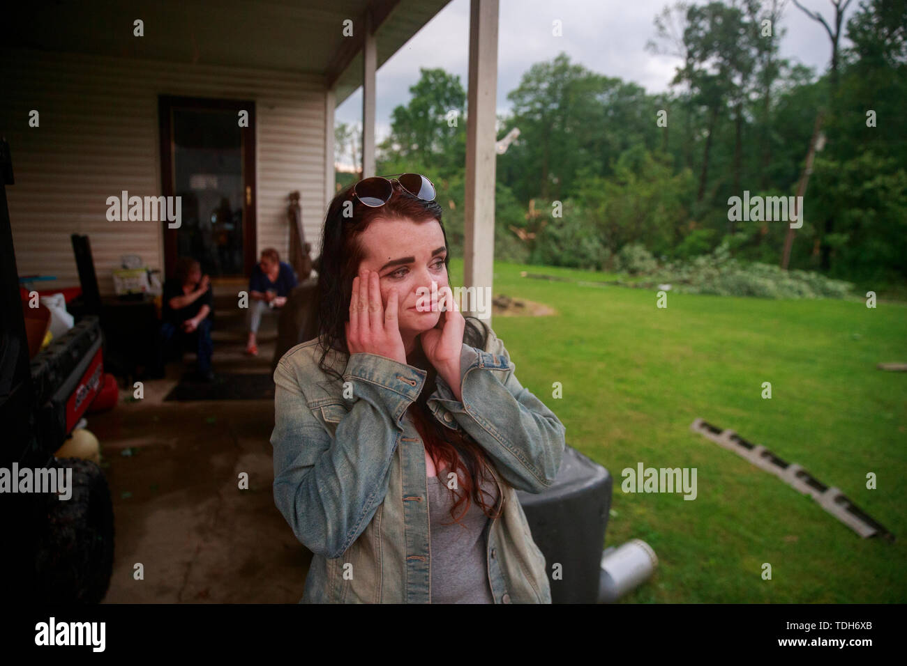 Ellettsville, USA. 15th June, 2019. Nicole Rood reacts after telling how she survived a tornado by holding onto the door handle of a house as she was lifted off the ground in the 6400 block of West Cowden Rd. near Ellettsville. Rood's boyfriend Brett Cantrell survived by hanging onto a tree across the road. The couple were in their car when the storm stuck. The tornado destroyed several homes, tore up trees, and left dangerous live power lines scattered around the area. Credit: SOPA Images Limited/Alamy Live News Stock Photo