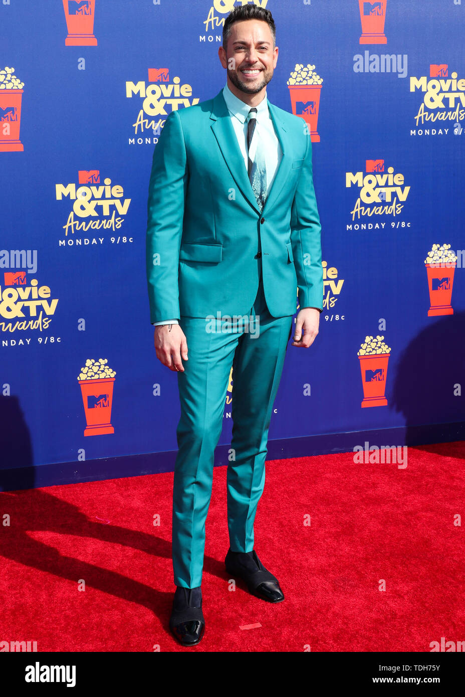 Actor Zachary Levi wearing a Paul Smith suit, Anto shirt, Christian  Louboutin shoes, and a Montblanc watch arrives at the 2019 MTV Movie And TV  Awards held at Barker Hangar on June