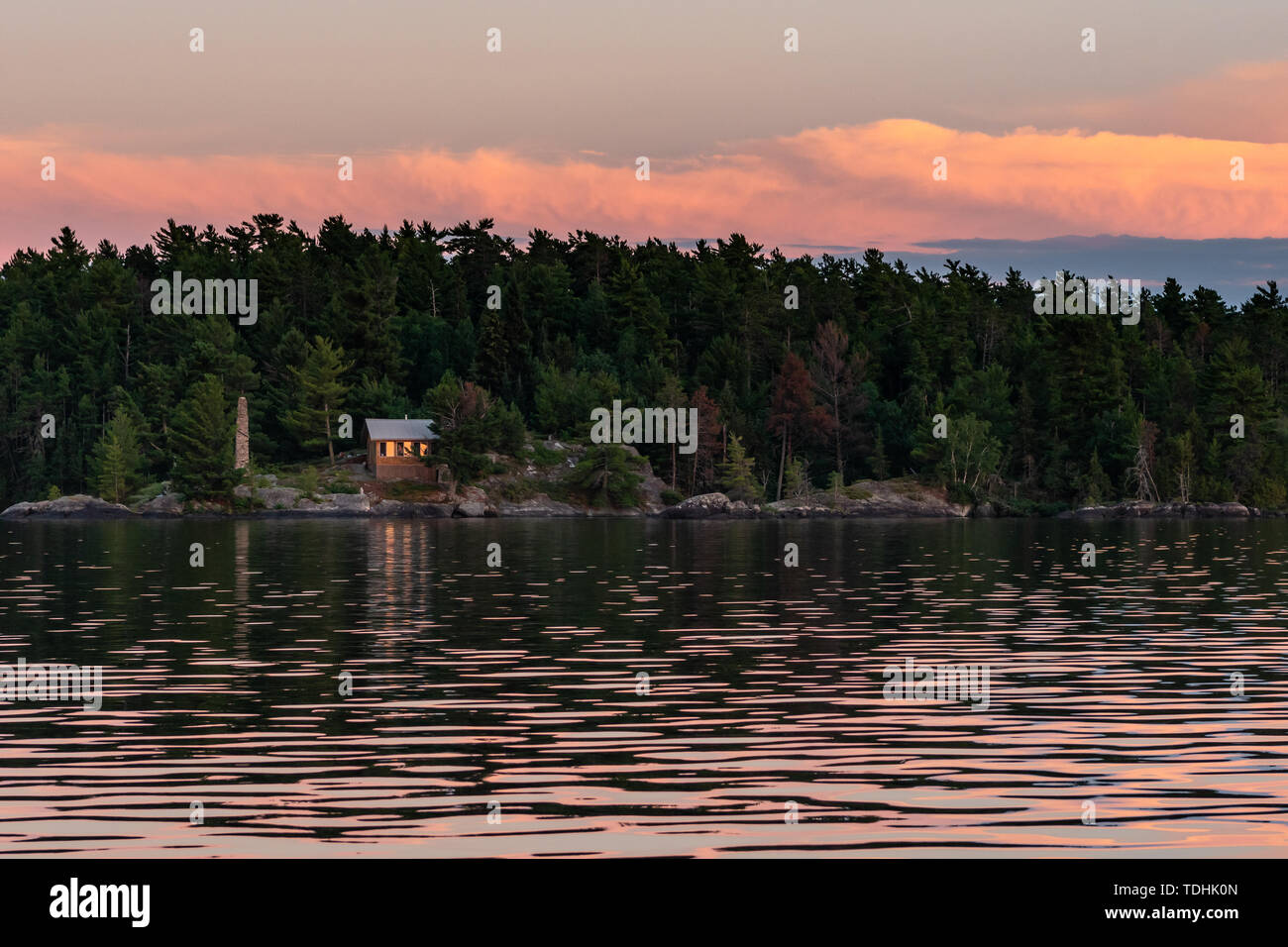 Rustic Cabin On Island In Rainy Lake At Sunset Stock Photo