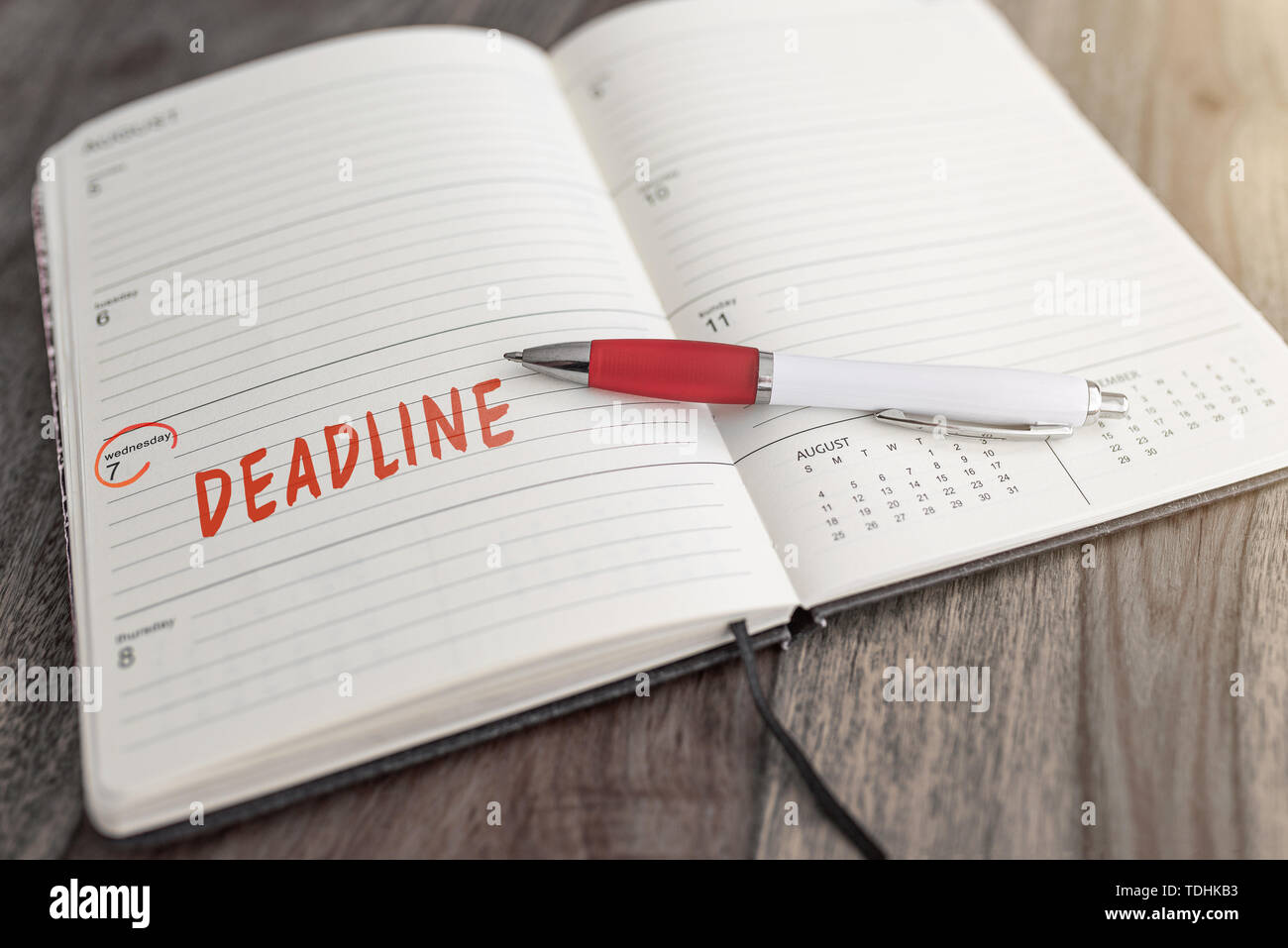 project deadline date marked in red in calendar on table business concept Stock Photo