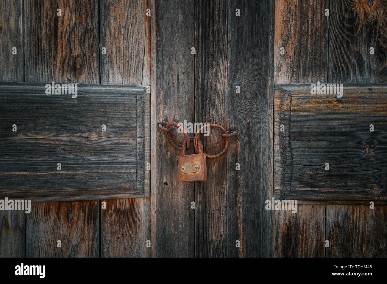 Old rusty lock on the brown vintage wooden door. Stock Photo