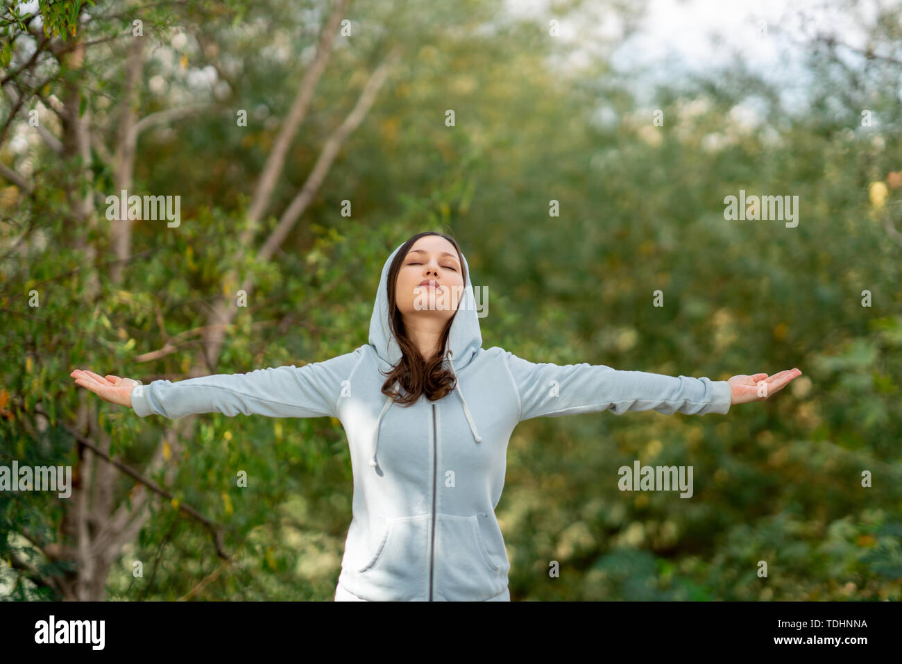 Beautiful woman doing breathing deep exercises in a park. Stock Photo