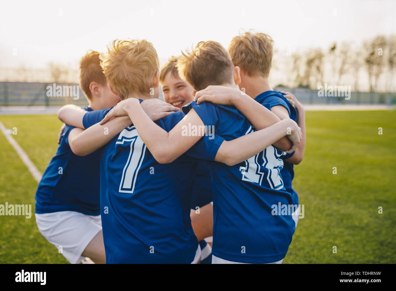 Group of friends happy kids in school sports team. Boys gathering and having fun on sports field. Cheerful children boys players of school soccer team Stock Photo