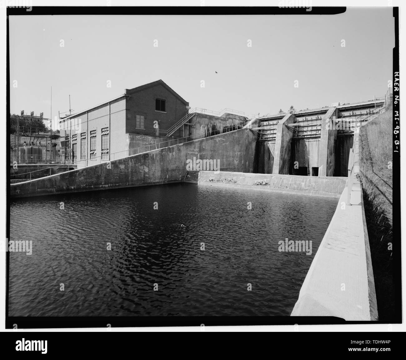 OVERALL VIEW OF SPILLWAY SHOWING BAFFLE WALL AND TAIL WATERS, WITH POWERHOUSE (MI-98-C) AND SUBSTATION (MI-98-D) AT LEFT. VIEW TO SOUTH. - Cooke Hydroelectric Plant, Spillway, Cook Dam Road at Au Sable River, Oscoda, Iosco County, MI Stock Photo