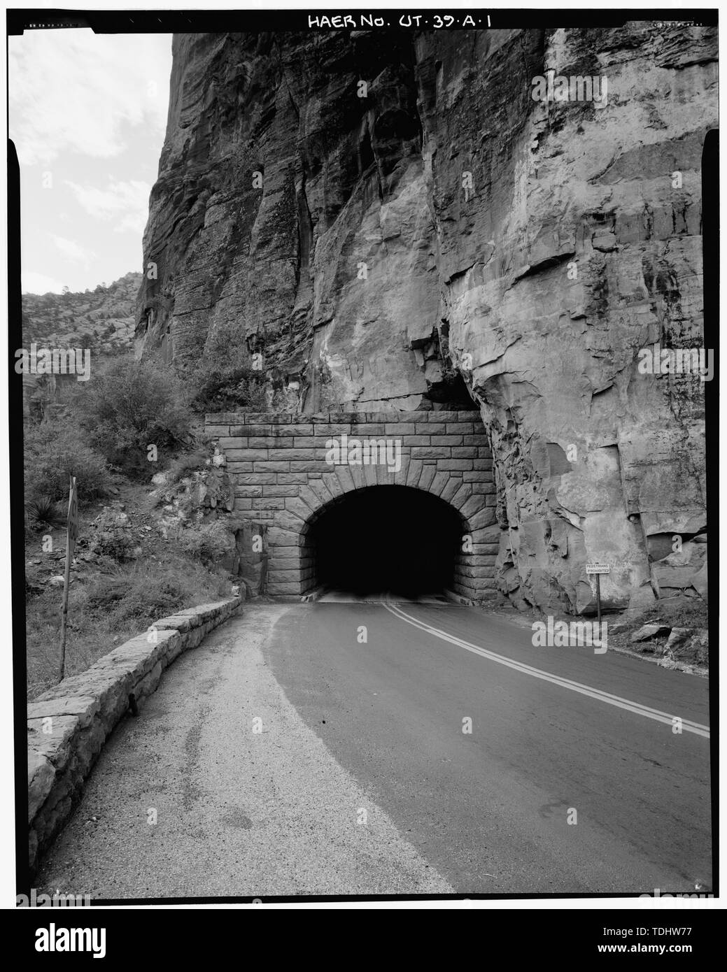OVERALL VIEW OF WEST PORTAL AND GUARDRAIL, LOOKING SOUTHEAST - Zion-Mount Carmel Highway, Tunnel, Two miles east of Zion Canyon Scenic Drive, Springdale, Washington County, UT; Nevada Construction Company; Bureau of Public Roads; Finch, J B; Mitchell, R R; Campbell, K B; Jones, T A; Scott, R N; Gregory, Herbert E; Cement Gun Construction Company; US Geologrical Service; US Bureau of Mining; Crane, W R; Reynolds-Ely Construction Co; Case Construction Company; Shea and Shea; Jurale, James, historian; Fraser, Clayton B, photographer; Anderson,  Michael, historian; Grogan, Brian C, photographer Stock Photo